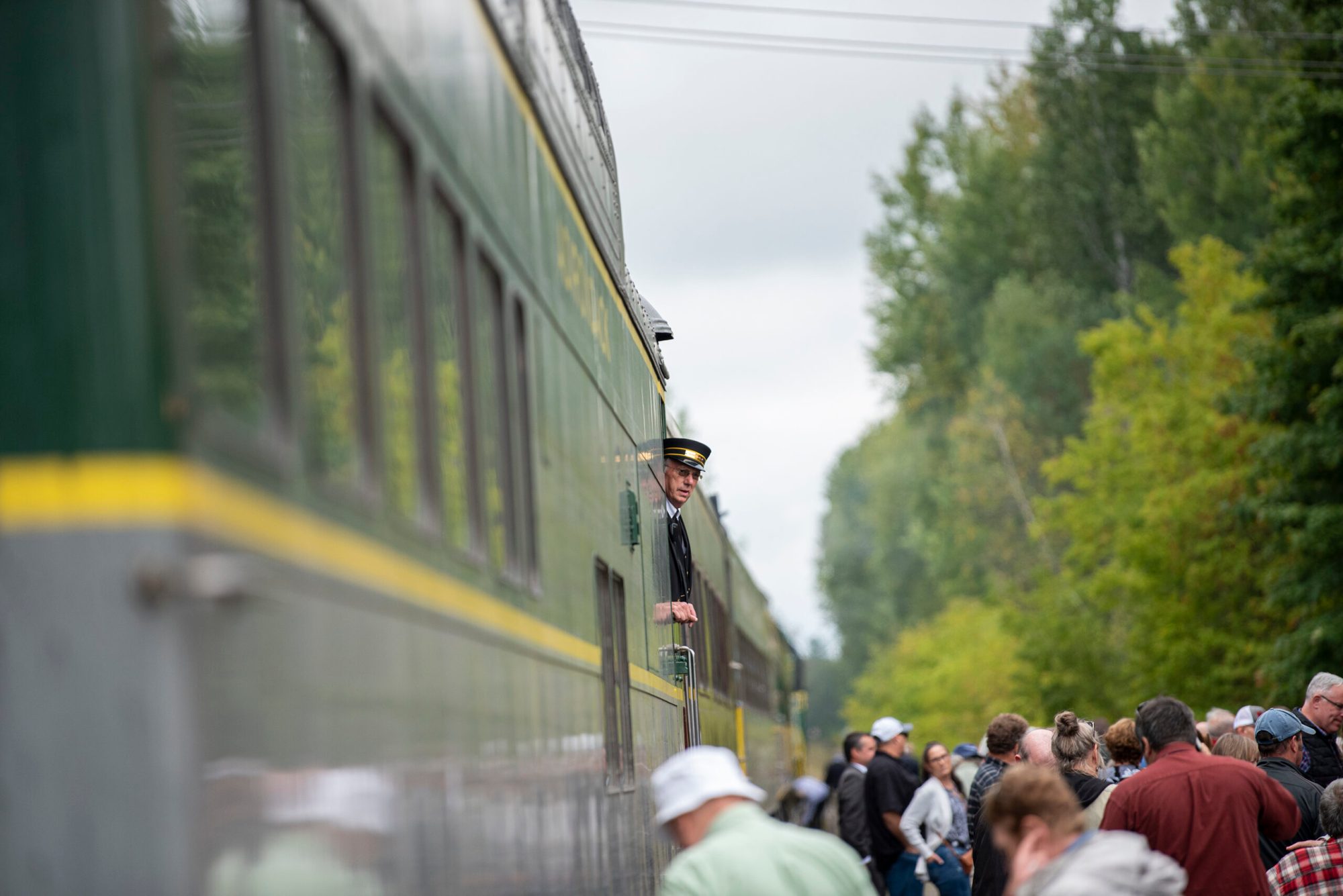 a group of people walking down a street next to a train