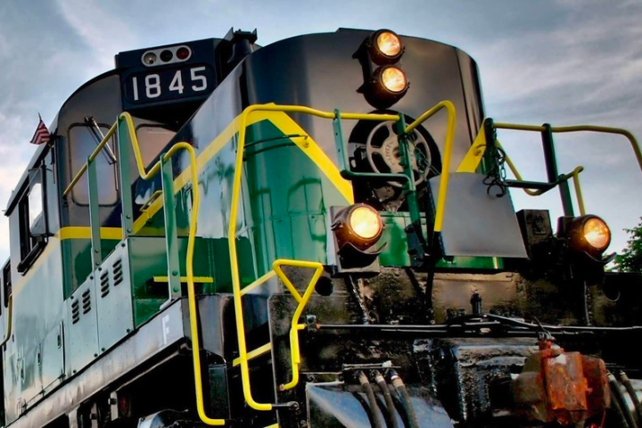 Close-up of a green and black locomotive with yellow accents.