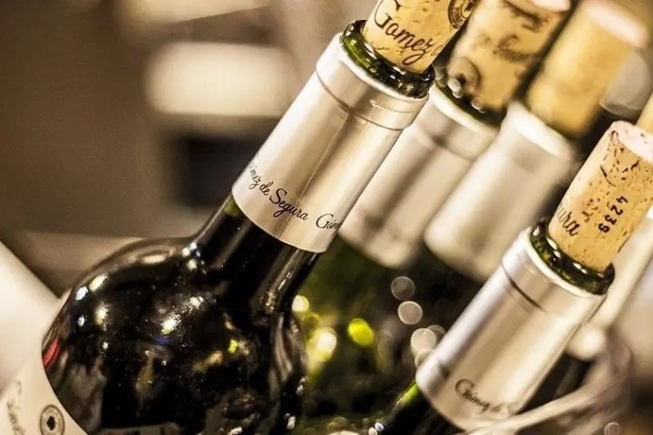 Close-up of wine bottles with corks on a shelf.